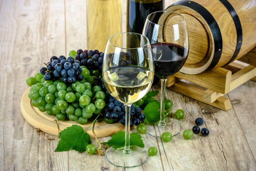 white and red wine with green and black grapes