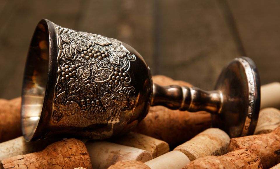 An ornate wine chalice resting on a bed of corks.